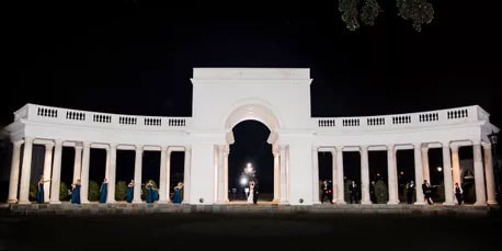 Stunning wedding party posing in front of the Colonnade at night - outdoor wedding venues - Lafayette Louisiana 