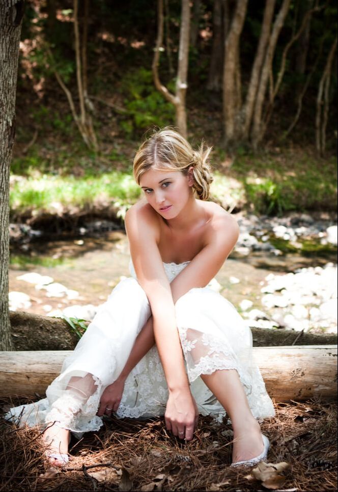 image of a lovely your bride sitting on a fallen tree in the woods - meeting spaces and reception venues - lafayette la - le pavillon