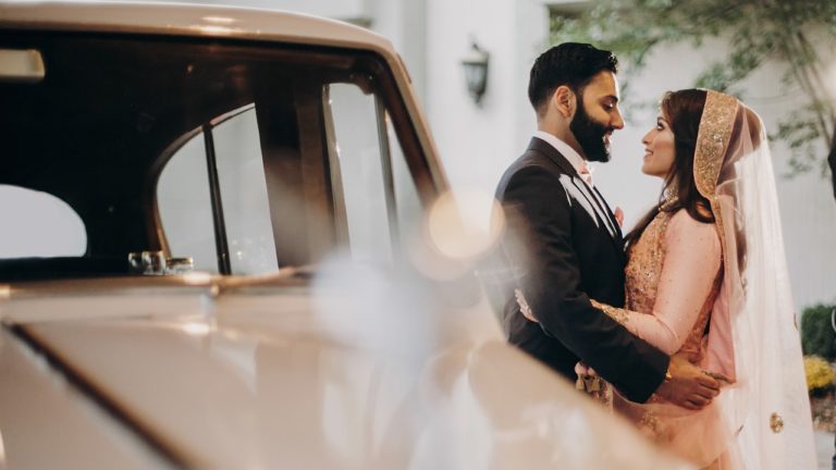 Picture of an Indian Couple embraced in front of a rolls royce - event centers in lafayette la - Le Pavillon at Parc Lafyette